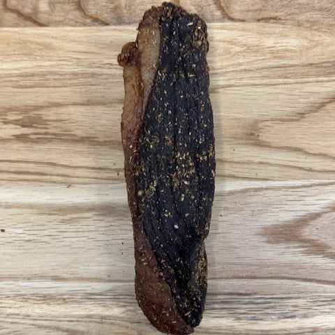 Whole piece of Peri peri biltong from Biltong Direct arranged on a wooden surface.