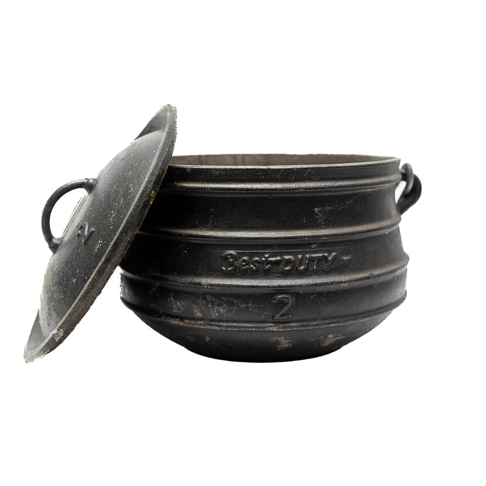 A black cast iron flat bottom potjies and a lid from Biltong Direct, on a white background.
