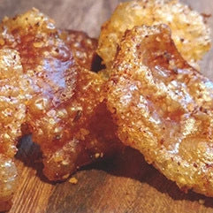 Close-up of pork scratching from Biltong Direct on a wooden surface