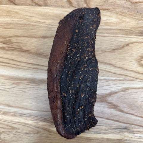 Full piece of trekkers biltong from Biltong Direct arranged on a wooden surface.