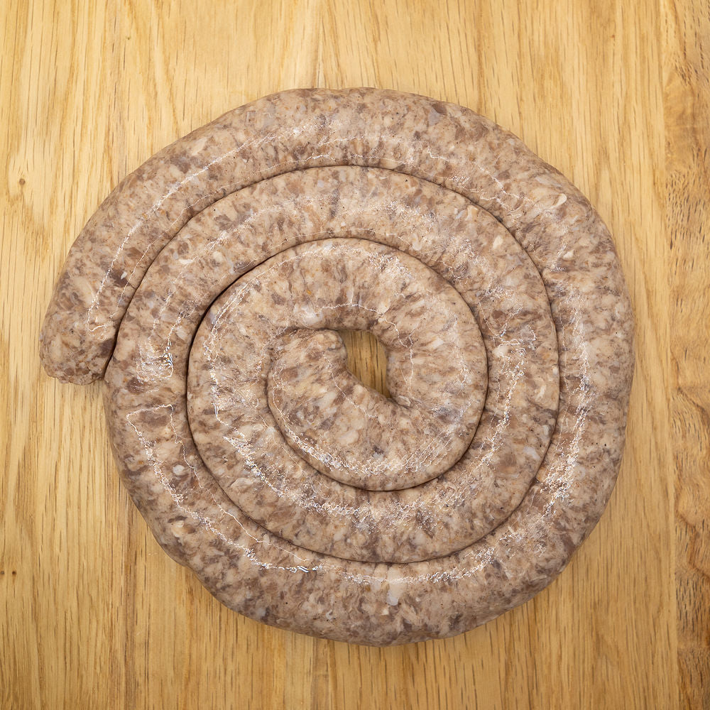 A large coil of pork-free Boerewors from Biltong Direct made with lamb and beef, displayed on a wooden surface.