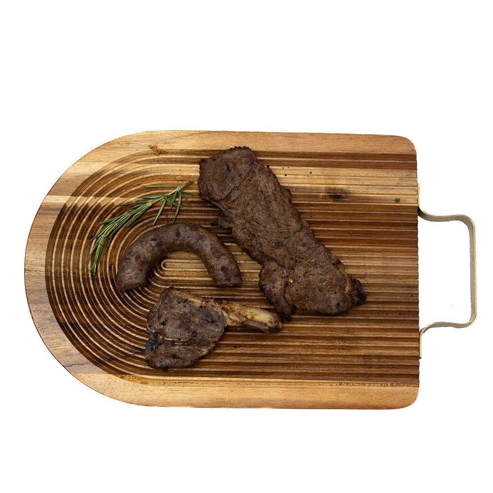 Cooked braai pack boerewors, lamb chop and a steak from Biltong Direct on a wooden board