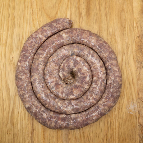 A coil of raw gluten free Boerewors sausage from Biltong Direct laid out on a wooden surface.