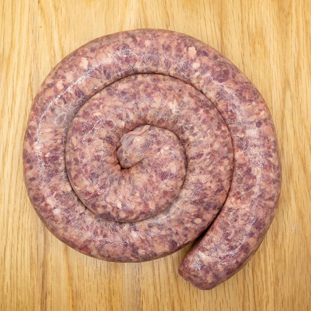 A coil of raw Ouma's Boerewors sausage from Biltong Direct laid out on a wooden surface.