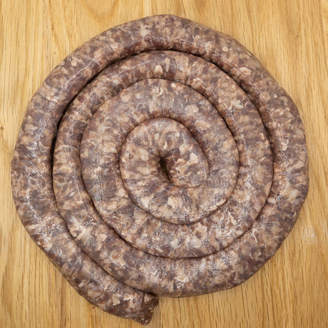 A large coil of traditional Mini Boerewors sausage from Biltong Direct laid out on a wooden surface.