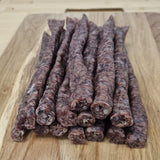 A bunch of traditional Droewors, drywors, cured sausage from Biltong Direct on a wooden cutting board.
