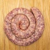 A large, coil of boerewors sausage from Biltong Direct made of meat and cheese, displayed on a wooden surface.