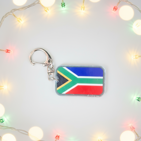 Keychain with South African flag design on a light background with string lights