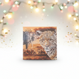 Canvas print of a leopard with other animals on a white wall with festive lights.