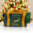Green and yellow bag with 'World Champions' and 'Springboks' text against a blurred festive background