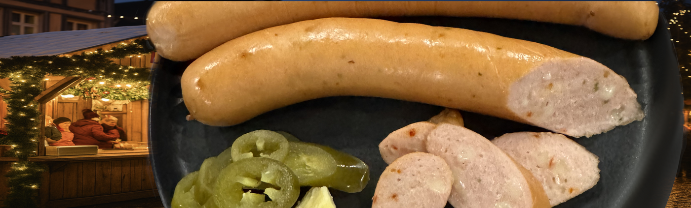 Platter of sausages with sliced jalapeños on a dark surface